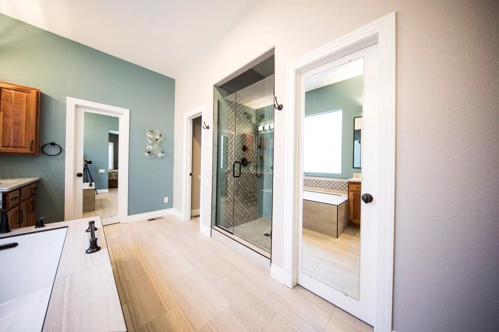 Bright bathroom with a glass shower enclosure, wood vanity and light flooring